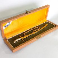 Abridor de envelopes: reprodução em miniatura da espada do Duque de Caxias. Acompanha o estojo de madeira nas cores marrom e amarelo. Pertenceu ao Sr. Ernani Zetola.